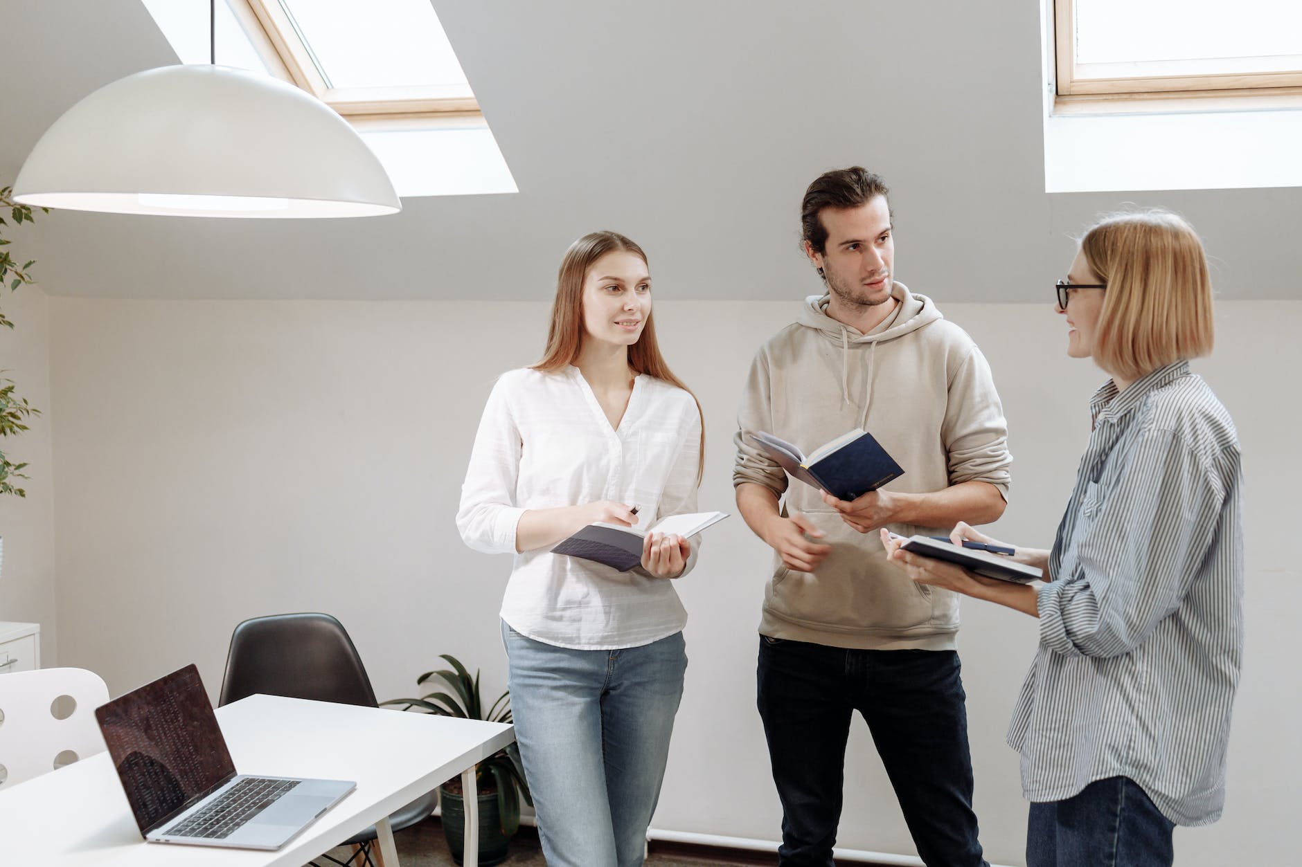 people standing near white table with laptop